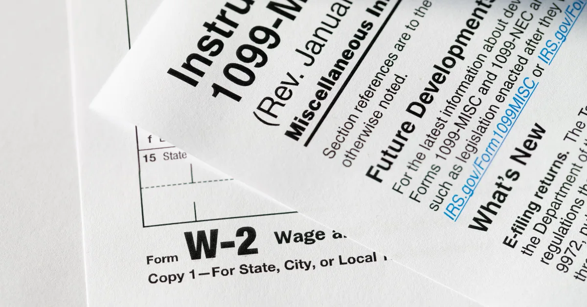 close-up photo of a 1099 form stacked on top of a W2 form (featured image: "1099 vs. W2: Understanding Employment Classification and Its Implications" article)